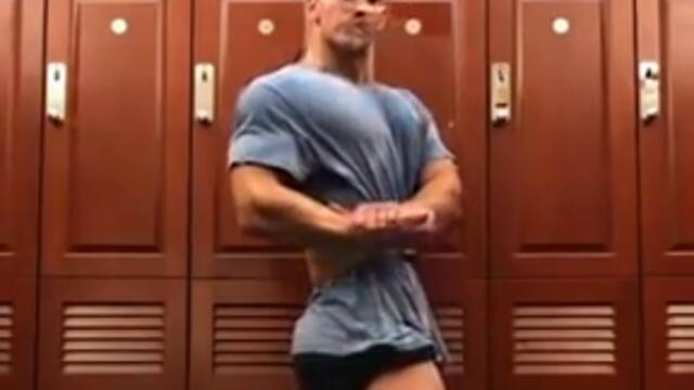 Older guy gropes a bodybuilder’s legs in a gym locker room