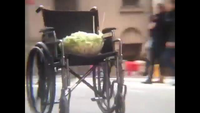 A bowl of salad in the seat of a wheelchair rolling down the street unassisted (with Diana Ross)