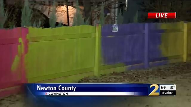 Fence fight: Woman paints fence neon colors after neighbor complains to county